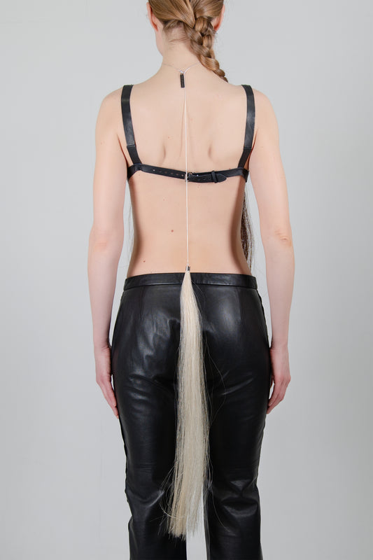 HORSE HAIR REVERSE NECKLACE (BUTTERMILK), closer back view: chain from nape to waist, pale horse hair tassel over black trousers