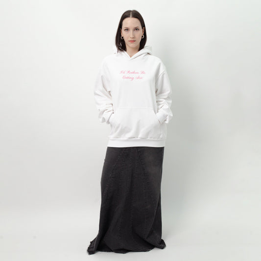 I'D RATHER BE EATING ASS CURSIVE HOODIE full-length on a model: white oversized hoodie worn with a long dark skirt