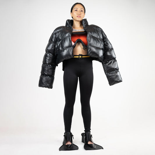 SCUBA PUFFER JACKET, full-length look: worn open over a goggle bra with belted black leggings and flipper-shaped heels