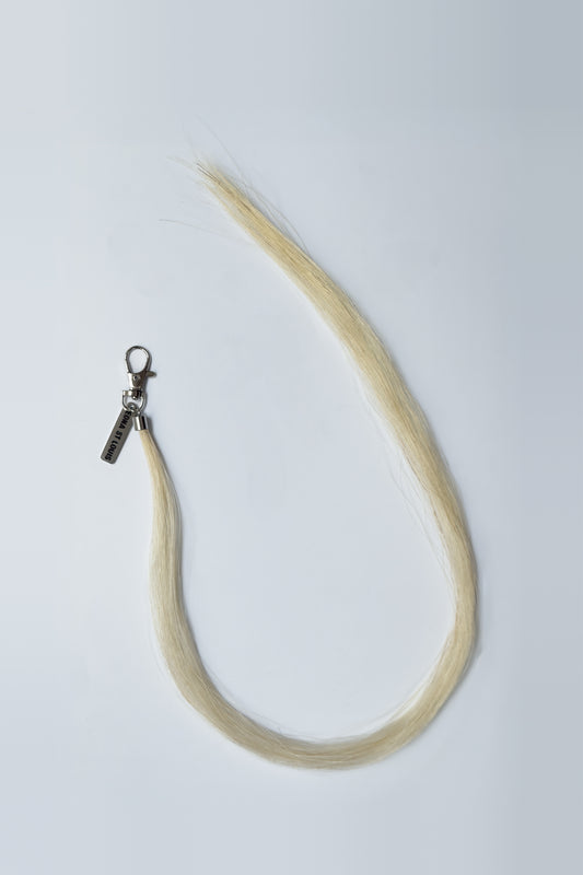 HORSE HAIR MULTI CHARM (BUTTERMILK): long buttermilk horse hair tassel curving from a silver lobster clip, top view