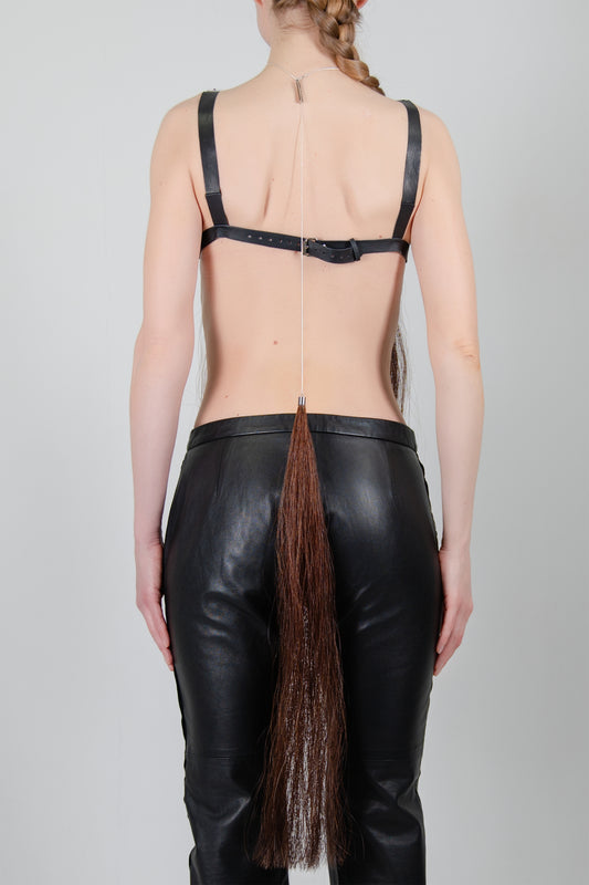HORSE HAIR REVERSE NECKLACE (CHESTNUT), closer back view: chain from nape to waist, chestnut tassel over black trousers
