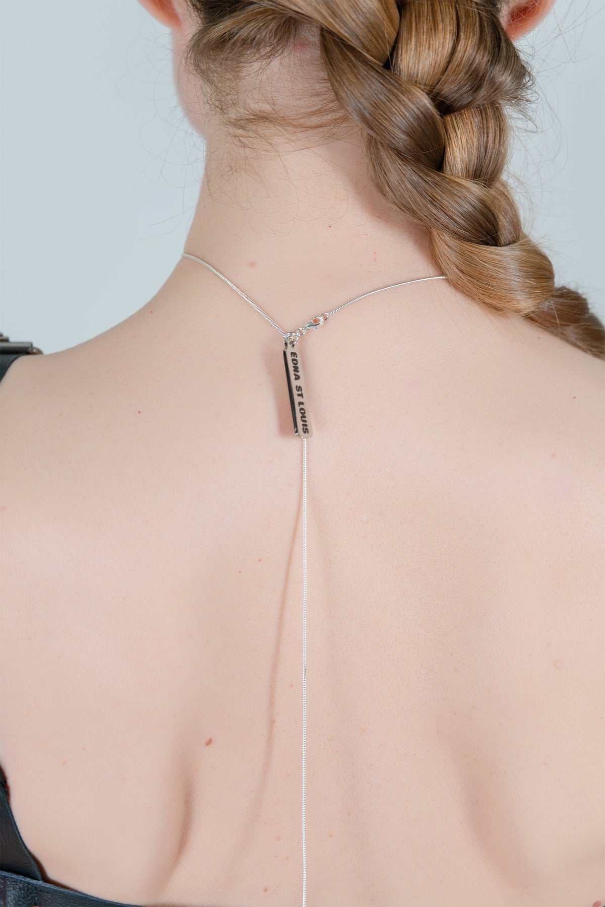 HORSE HAIR REVERSE NECKLACE (CHESTNUT), close-up at the nape: clasp and silver bar tag reading “EDNA ST LOUIS”