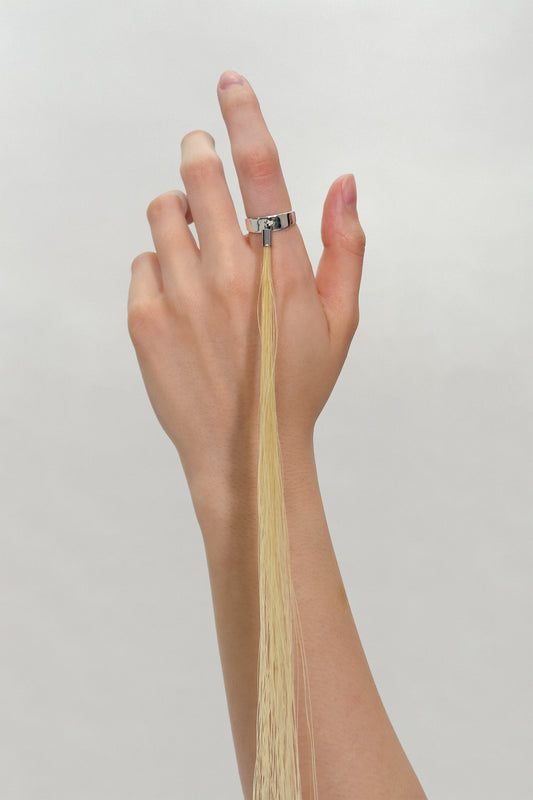 HORSE HAIR RING on a raised hand, silver band on the middle finger with the horse hair tassel running down the forearm