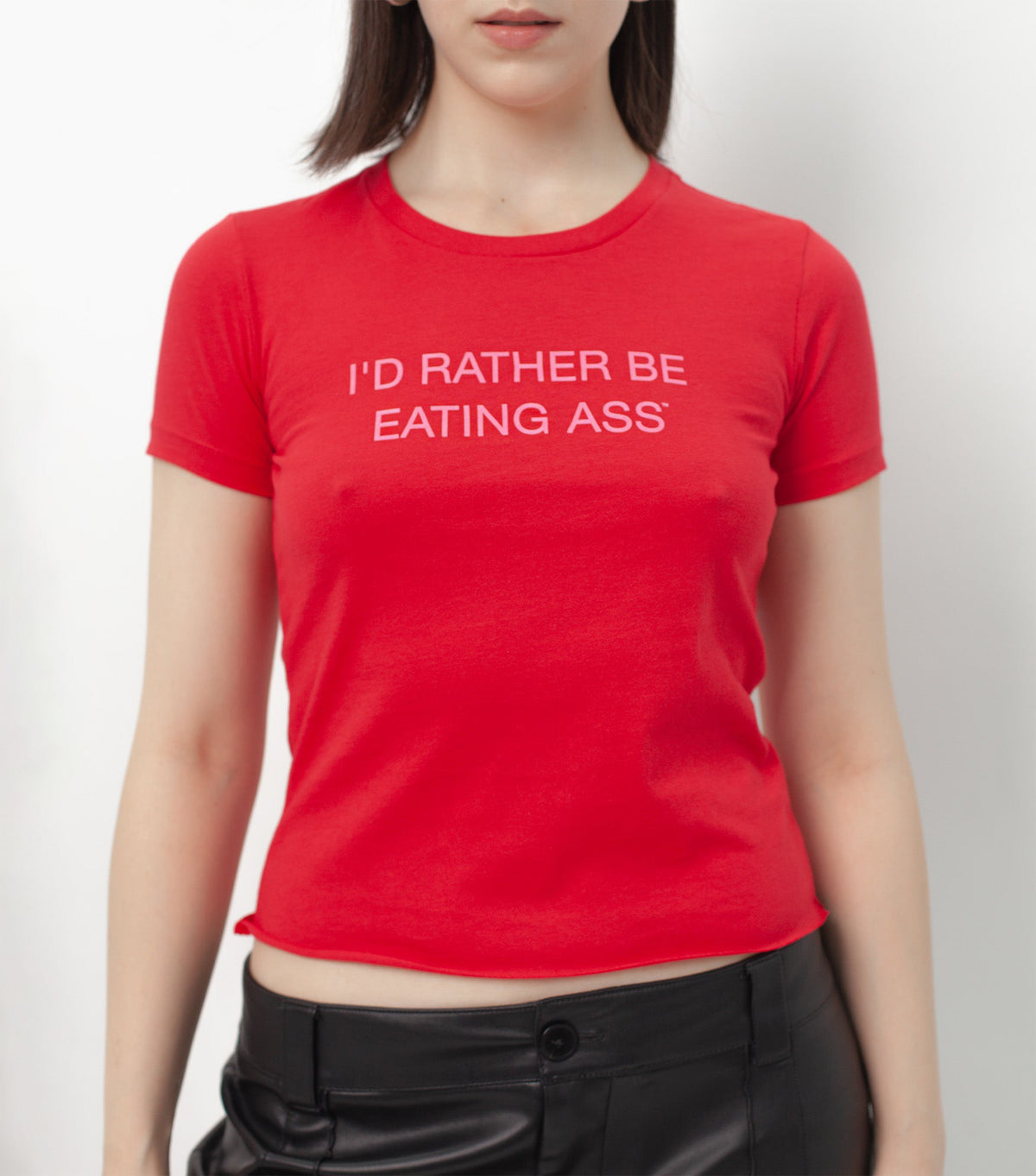 I'D RATHER BE EATING ASS T-SHIRT on a model, front view: skin-tight red tee with the slogan in baby pink across the chest