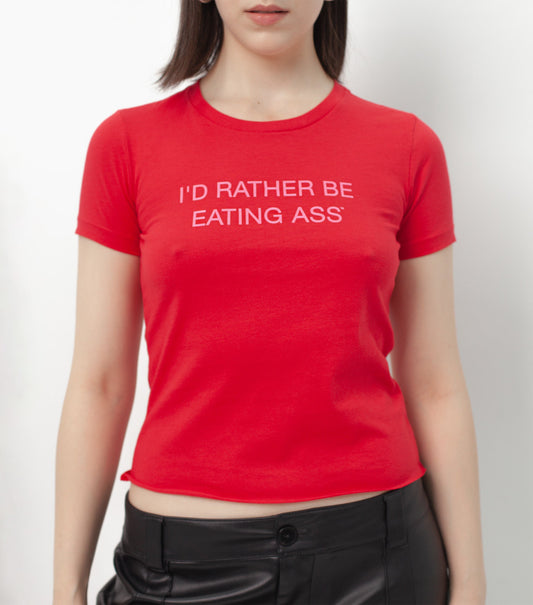 I'D RATHER BE EATING ASS T-SHIRT on a model, front view: skin-tight red tee with the slogan in baby pink across the chest