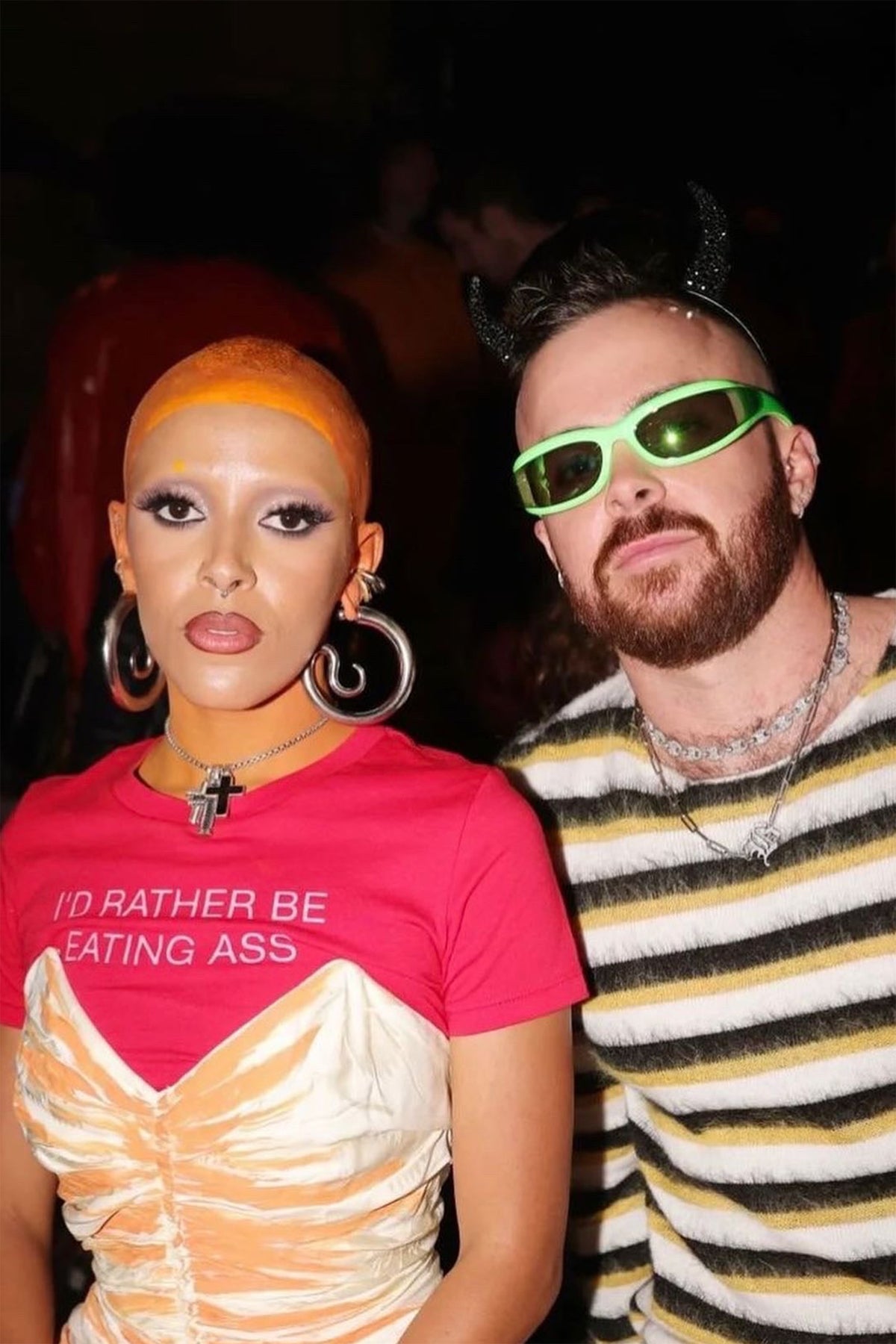I'D RATHER BE EATING ASS T-SHIRT worn by Doja Cat at an event, under a ruched cream-and-orange dress
