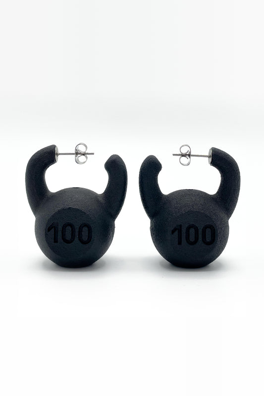KETTLEBELL EARRINGS, pair side by side on white: matte black kettlebells marked "100" with silver posts and backs