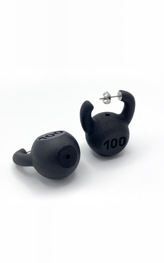 KETTLEBELL EARRINGS, one upright and one on its side showing the flat base and the "100" marking
