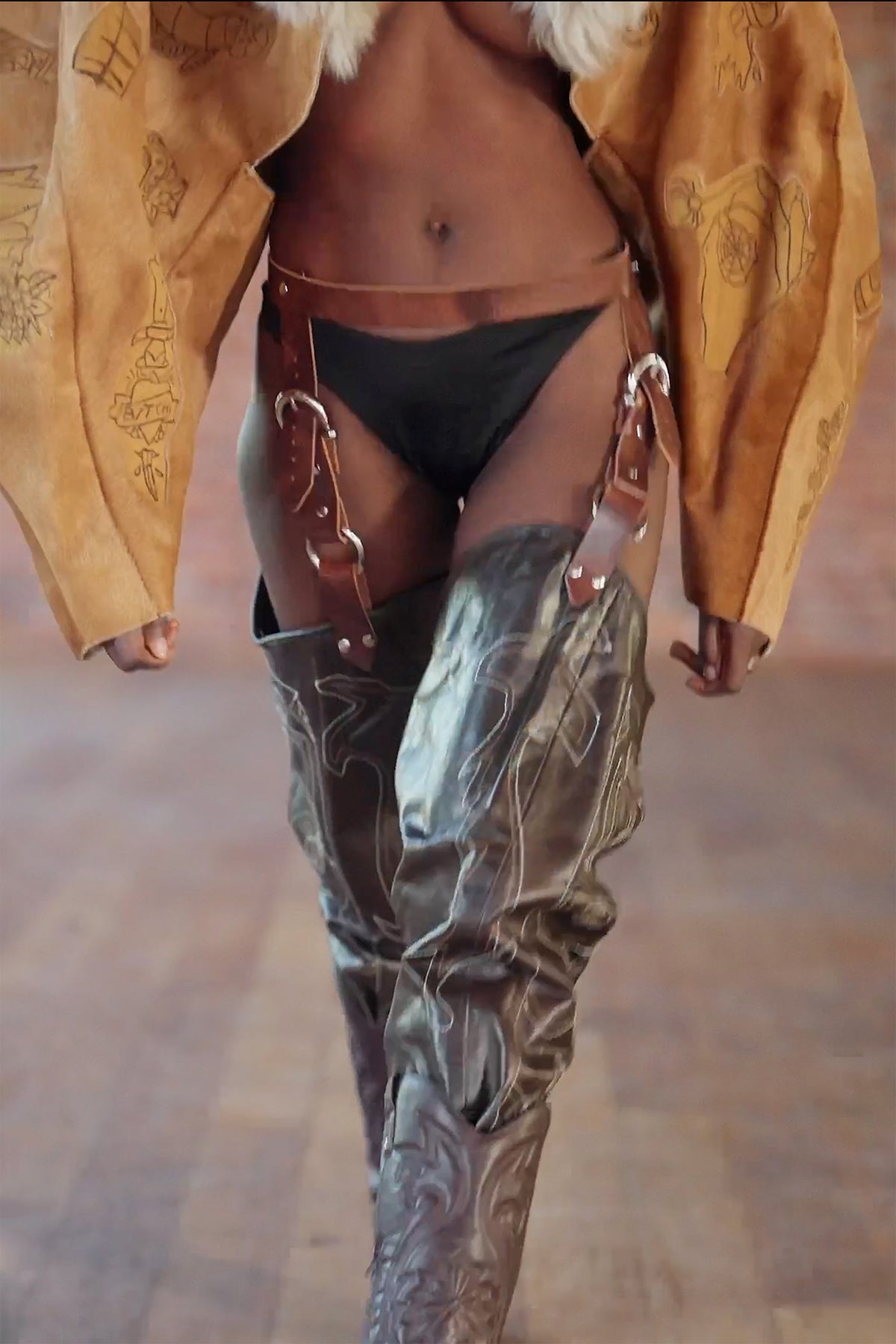 LOOK 3, Save A Horse, Ride A Cowboy: close-up of the brown belt and straps holding up the thigh-high cowboy boot chaps