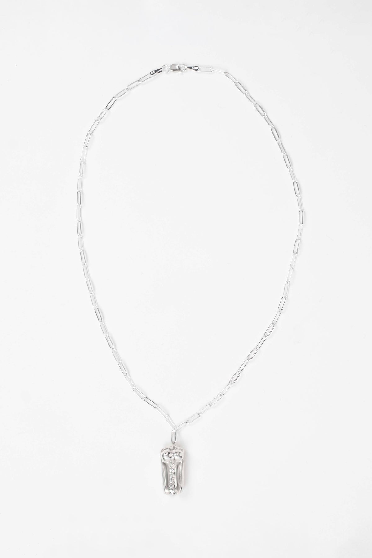 PENIS HOT DOG NECKLACE laid flat on white: full silver paperclip chain with clasp and the pendant