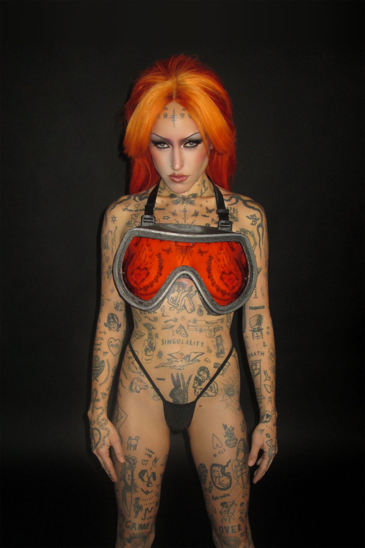 SCUBA BRA on a tattooed model with orange hair, chest visible through the orange transparent panel, black thong