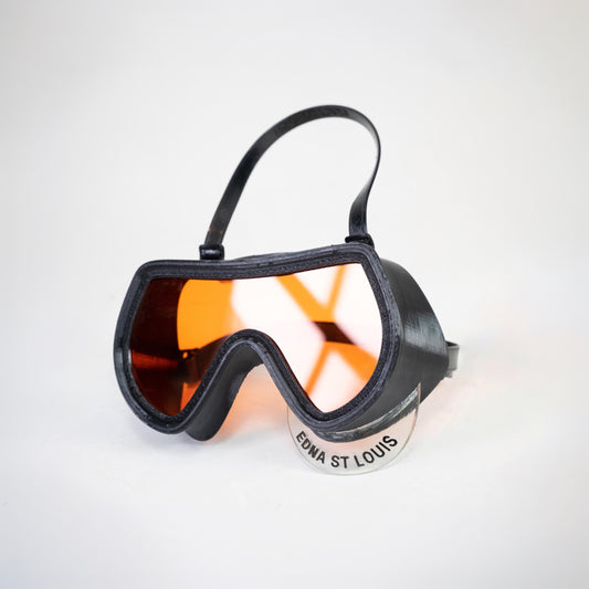 SCUBA BRA alone, black goggle-shaped frame with orange-tinted transparent acrylic front panel and strap, logo tab