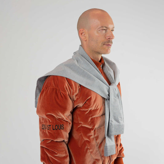 LIFT SHAWL, closer side view on a model: gray "legs" tied at the front, worn over a bronze velour jacket