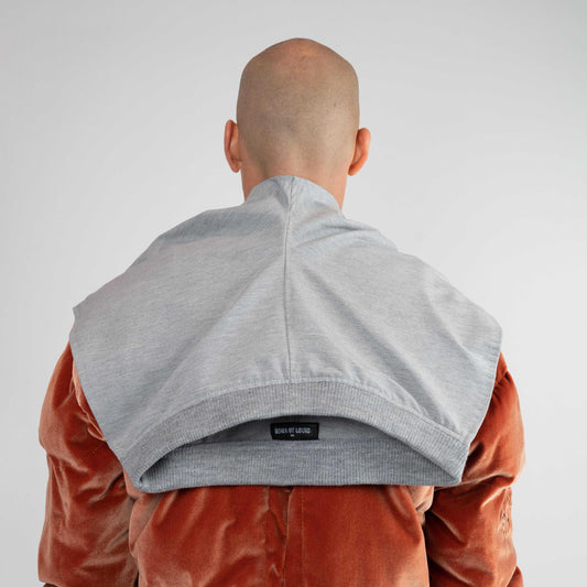 LIFT SHAWL, back view on a model: gray "sweatpants" seat over the shoulders with a black logo tag at the waistband