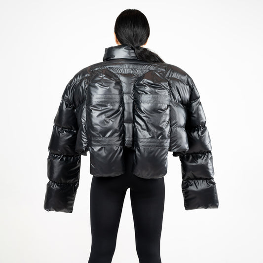 SCUBA PUFFER JACKET, back view: twin quilted scuba-tank panels across the back of the glossy black puffer