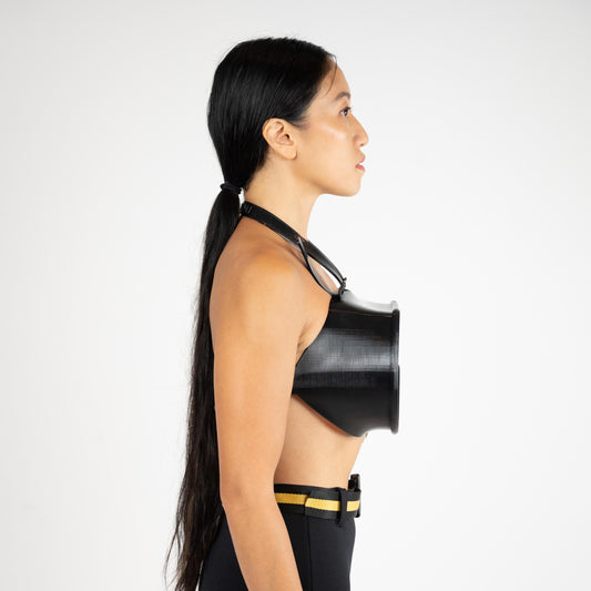SCUBA BRA side profile on a model, black 3D-printed TPU cup projecting from the chest on a halter strap