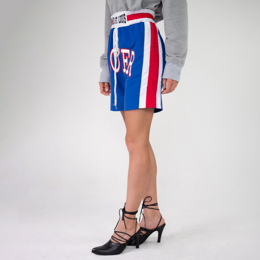 BOX TRACK PANT as boxing shorts, side view on a model in black lace-up heels, red and white side stripe