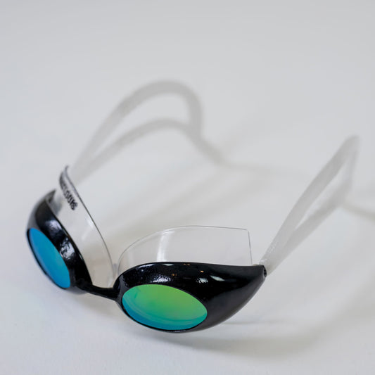 SWIM SUNGLASSES on their own, angled from the front: black goggle cups with blue-green lenses and clear arched temples